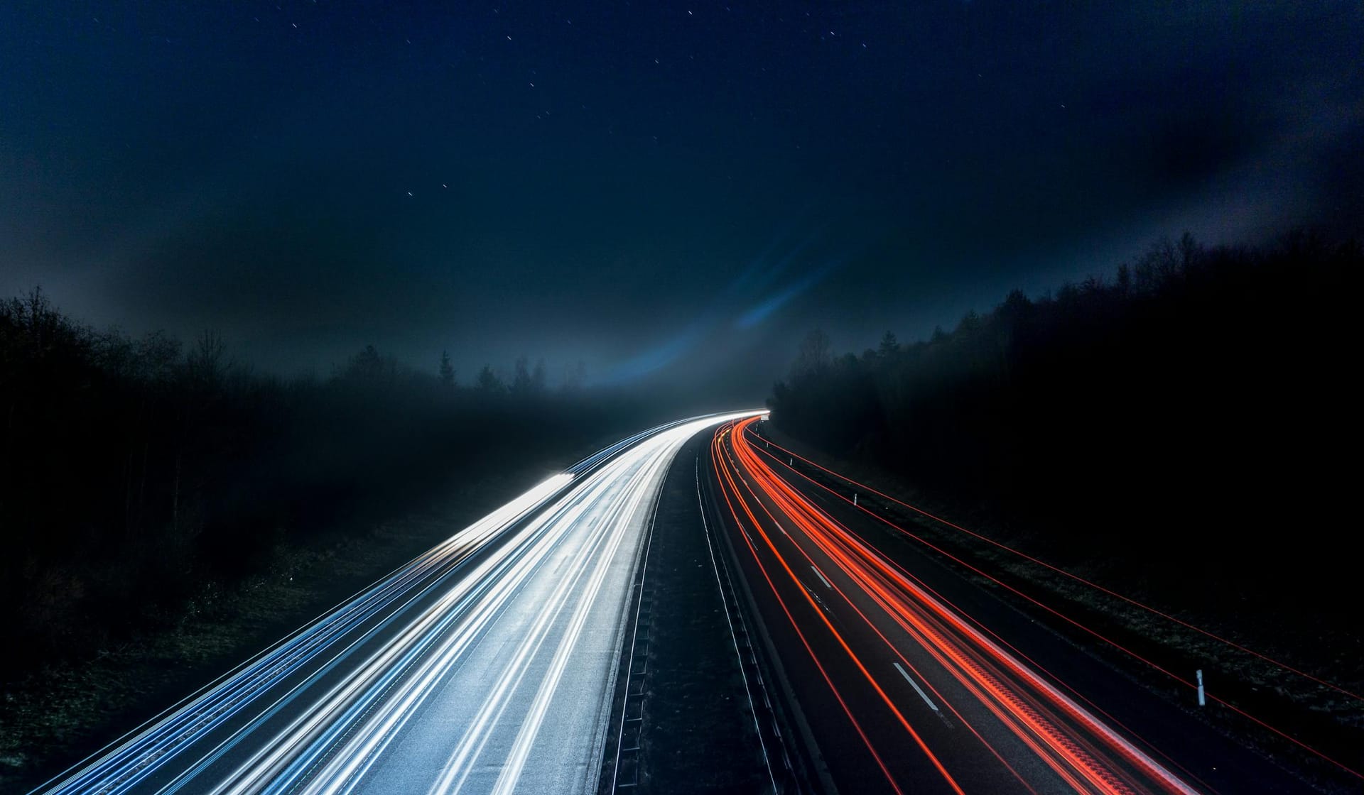Long-exposure light trails on a highway at night — discreet delivery across the central Suffolk corridor