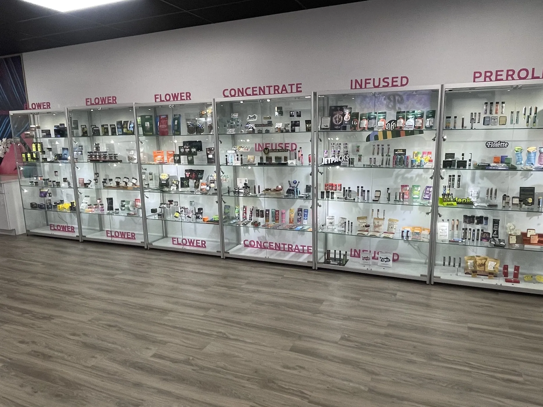 Beleaf Medford product display cases - flower, concentrate, infused, and preroll sections lined along the retail floor